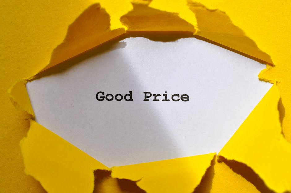 A piece of white paper with the words 'Good Price' printed in black sits inside a yellow paper envelope with torn edges, revealing the message through a jagged opening. The yellow envelope surrounds t
